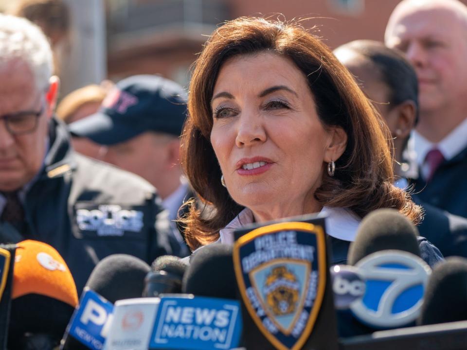 NY Gov. Kathy Hohchul addresses reporters while surrounded by police officers.