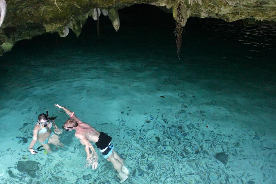 In this Jan. 4, 2013 photograph, a couple takes a picture while swimming in the Gran Cenote, a water cave near Tulum, Mexico. The water caves are popular destination among tourists visiting the beaches and resorts of the Yucatan Peninsula. (AP Photo/Manuel Valdes)
