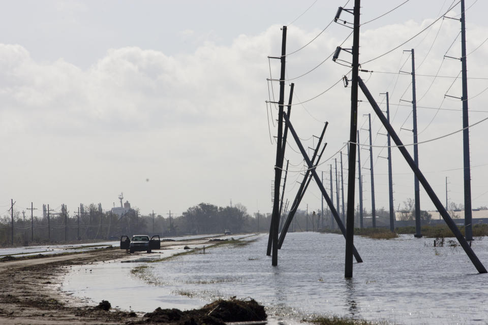 A truck is stranded from receding flood waters from Hurricane Isaac along Louisiana Hwy 23 near Port Sulphur, La., in Plaquemines Parish, Monday, Sept. 3, 2012. (AP Photo/Matthew Hinton)