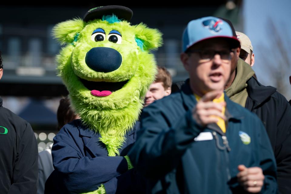 Eugene Emeralds mascot Sluggo listens as Eugene City Councilor Matt Keating speaks to members of the media during an event to discuss efforts to fund a new home for the Emeralds Friday, March 8, 2024 at PK Park in Eugene.