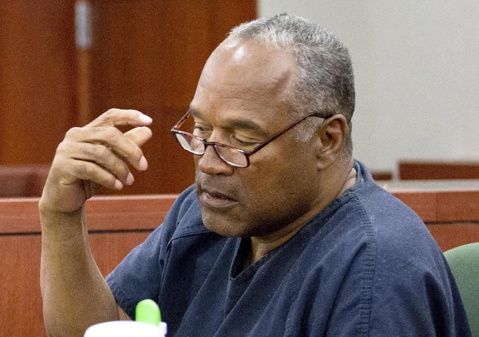 O.J. Simpson removes his glasses as he testifies during an evidentiary hearing in Clark County District Court, Wednesday, May 15, 2013 in Las Vegas. Simpson, who is currently serving a nine to 33-year sentence in state prison as a result of his October 2008 conviction for armed robbery and kidnapping charges, is using a writ of habeas corpus, to seek a new trial, claiming he had such bad representation that his conviction should be reversed. (AP Photo/Julie Jacobson, Pool)