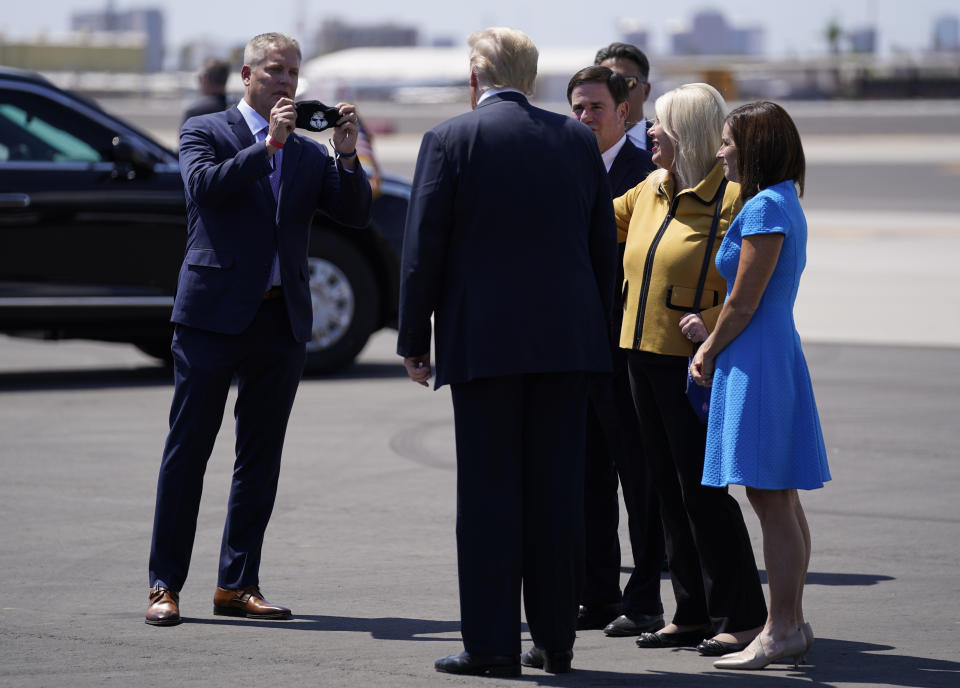 FILE - In this June 23, 2020, file photo, President Donald Trump, second from left, is met by Clint Hickman, left, vice chairman of Arizona's 4th District, Maricopa County Board of Supervisors, as he arrives at Phoenix Sky Harbor International Airport in Phoenix. The board that oversees Arizona's most populous county has scheduled a special meeting Friday, Sept. 17, 2021, where members may announce whether they will comply with a state Senate subpoena to hand over its computer routers for examination by contractors conducting an unprecedented partisan review of 2020 election results. ( AP Photo/Evan Vucci, File)