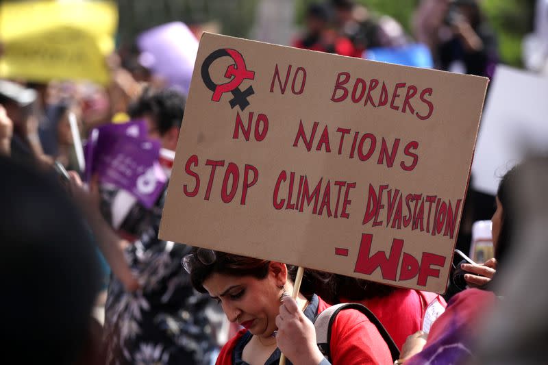 A woman carries a sign as she takes part in an Aurat March, or Women's March in Lahore,