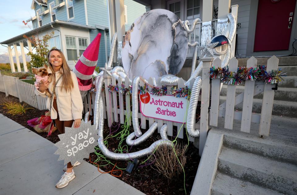Deidra Smith works on hanging a “Yay, space” sign in front of her house, which is decorated in an Astronaut Barbie theme for Halloween, in South Jordan on Friday, Oct. 13, 2023. | Kristin Murphy, Deseret News