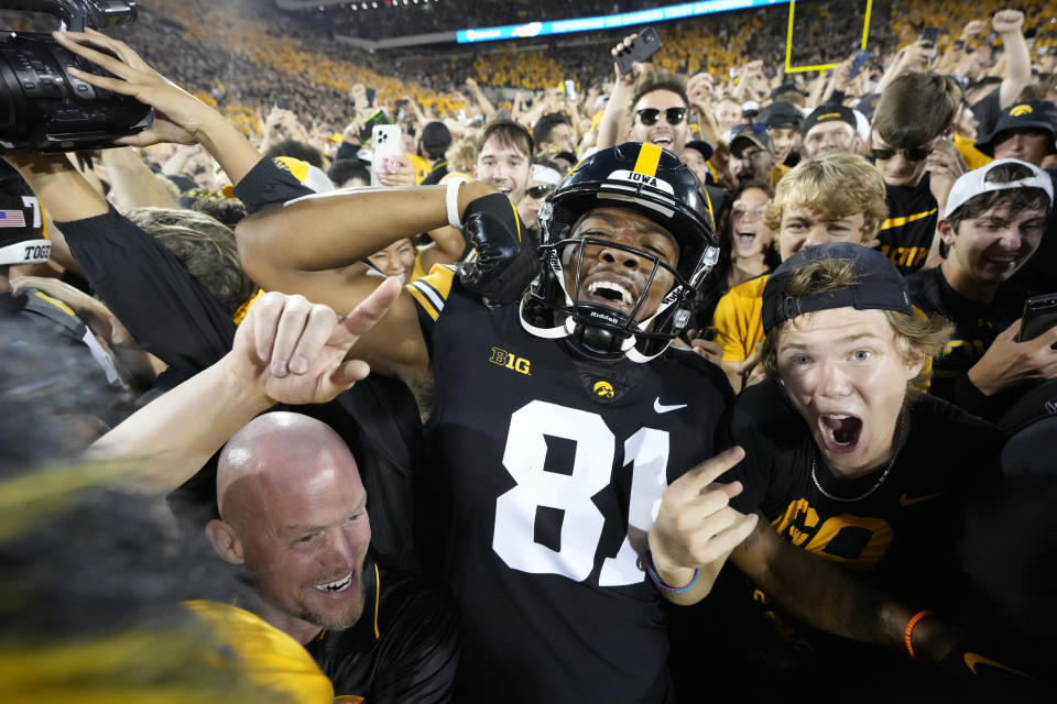 Iowa wide receiver Desmond Hutson (81) celebrates with fans on the field after Iowa beat Penn State 23-20, in an NCAA college football game, Saturday, Oct. 9, 2021, in Iowa City, Iowa. (AP Photo/Matthew Putney)