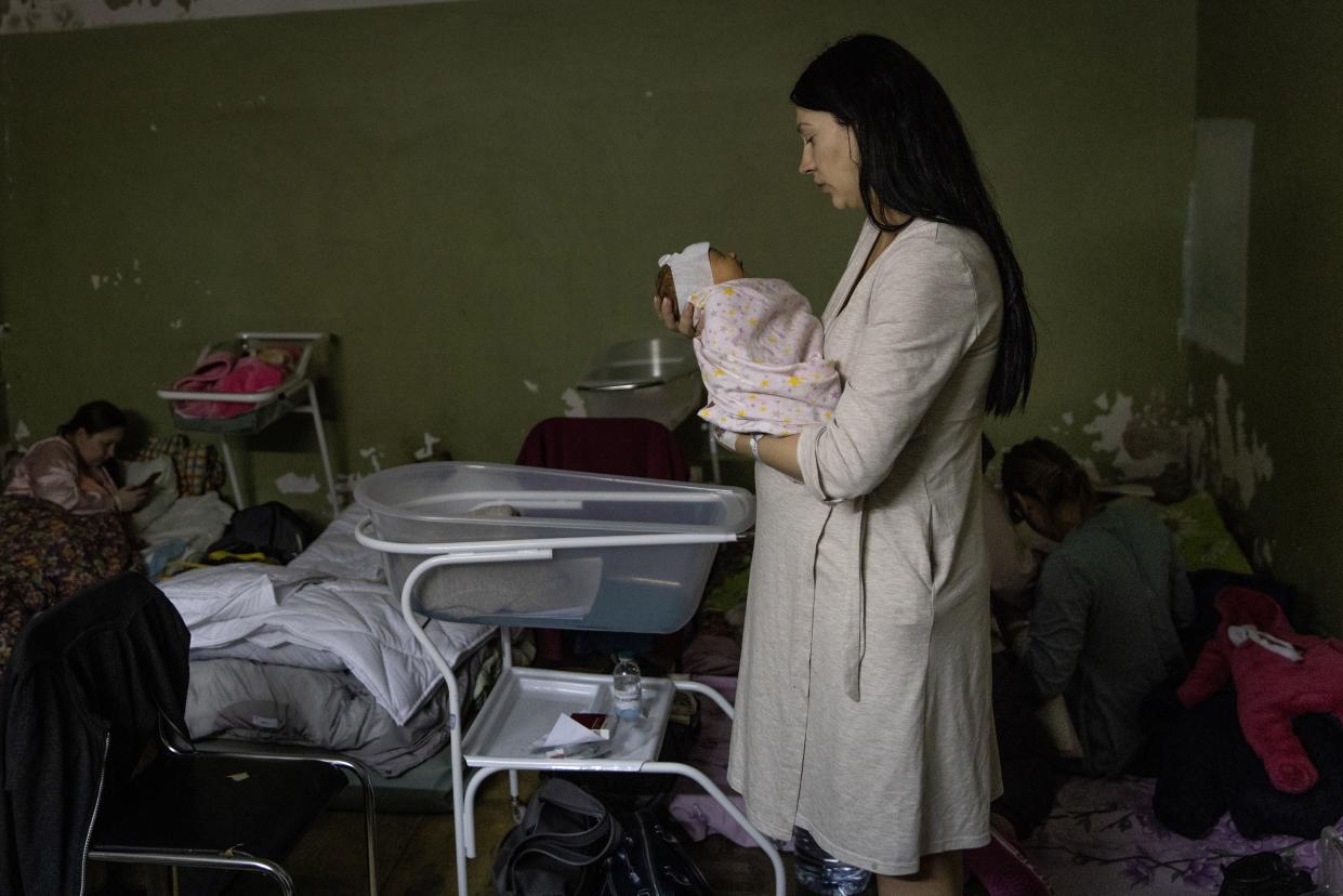 A mother holds her newborn baby in the bomb shelter of a maternity hospital on March 2, 2022, in Kyiv, Ukraine. Russian forces continued their advance on the Ukrainian capital for the seventh day as the country's invasion of its western neighbor goes on. Intense battles are also being waged over Ukraine's other major cities.