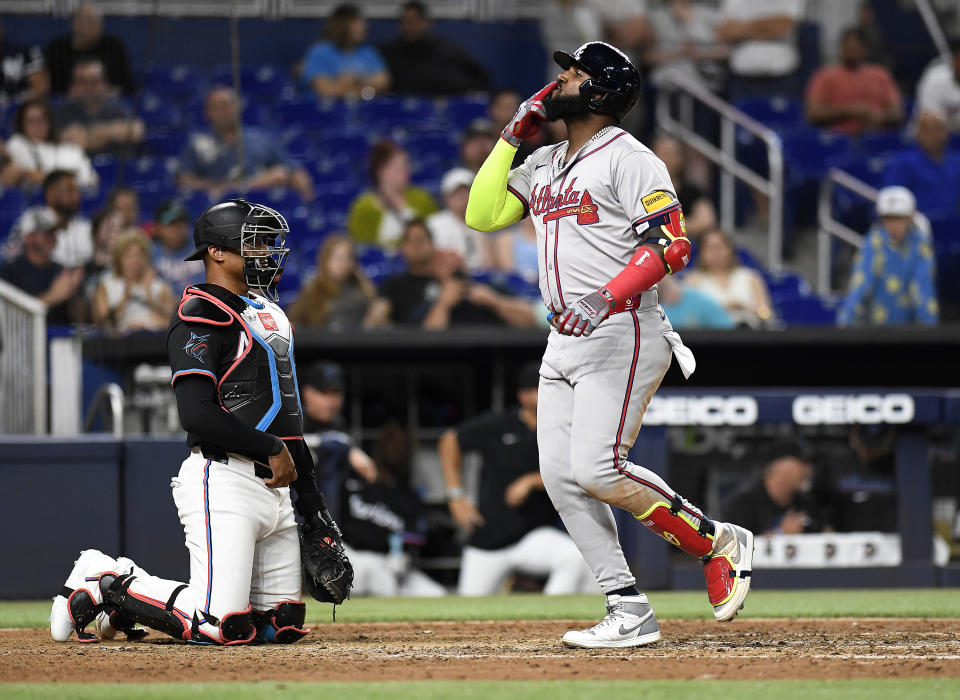 Atlanta Braves designated hitter Marcell Ozuna walks across home plate in front of Miami Marlins catcher Nick Fortes during the ninth inning of a baseball game, Friday, April 12, 2024, in Miami. (AP Photo/Michael Laughlin)