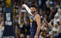 Denver Nuggets guard Jamal Murray looks back at the Los Angeles Lakers bench after hitting a 3-point basket late in the second half of Game 5 of an NBA basketball first-round playoff series Monday, April 29, 2024, in Denver. (AP Photo/David Zalubowski)