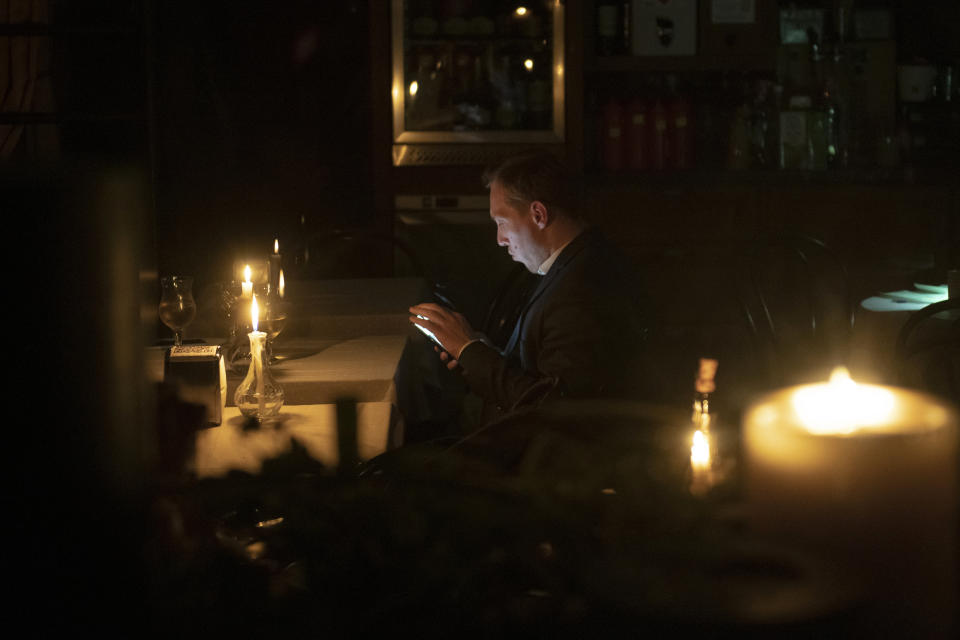 A man sits in a caffe during a blackout in Kyiv, Ukraine, Friday, Nov. 4, 2022. (AP Photo/Andrew Kravchenko)