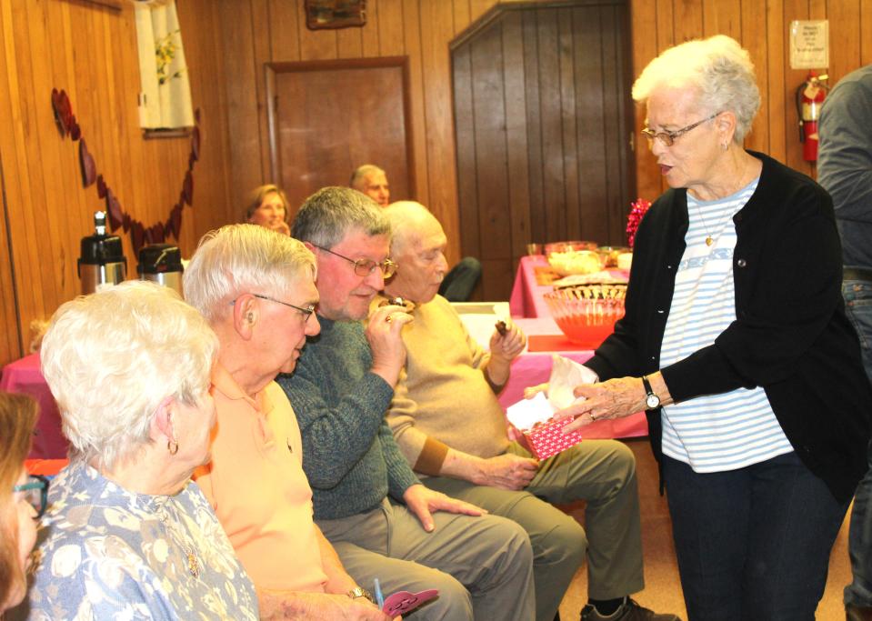 Almeda Miller shows candy to bidder's row, Bev and Ken Warnick, John Smaila and Fred DiPasquale, all of whom come out to every Death By Chocolate event by buying many items to support the Meyersdale Public Library.