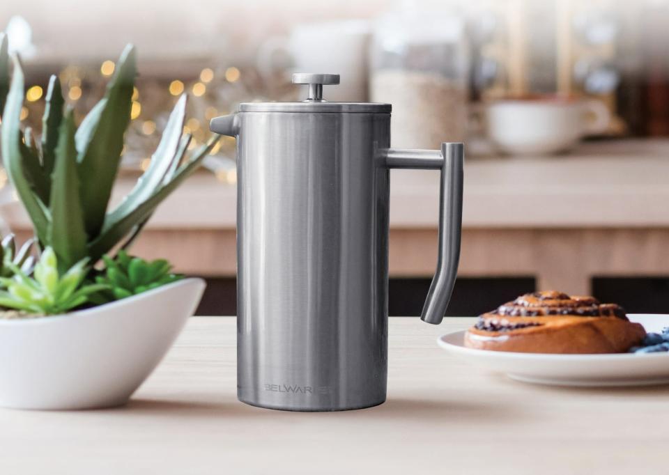 A large stainless steel french press on a counter
