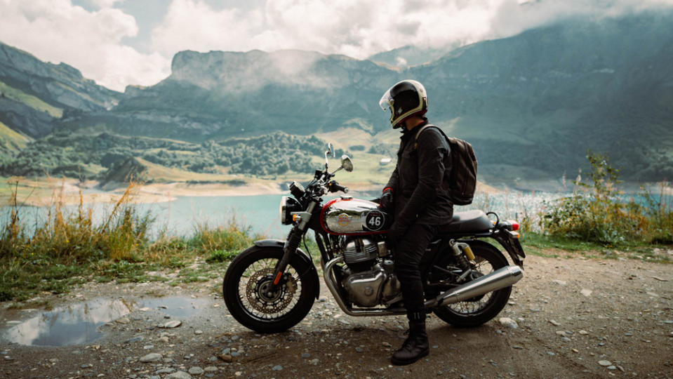 A motorcyclist, on a Royal Enfield Interceptor 650, takes a break to enjoy the view during the 2022 Great Malle Mountain Rally.