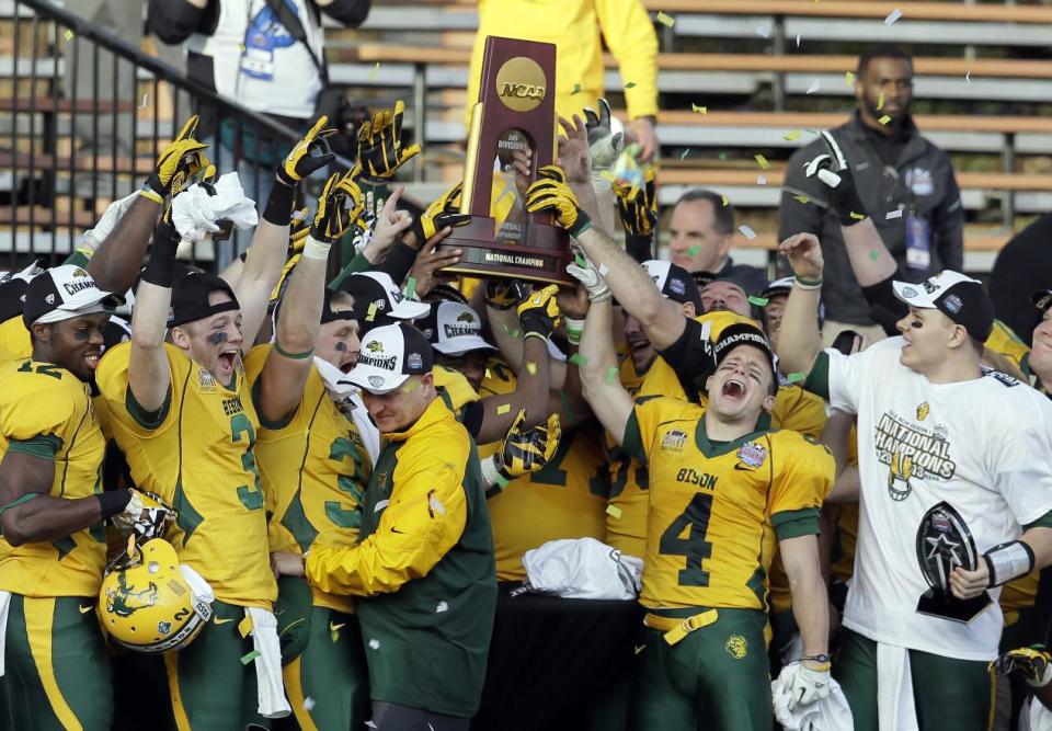 North Dakota State players celebrate with the trophy after winning the FCS championship NCAA college football game against Towson, Saturday, Jan. 4, 2014, in Frisco, Texas. NDSU won 35-7. (AP Photo/Tony Gutierrez)