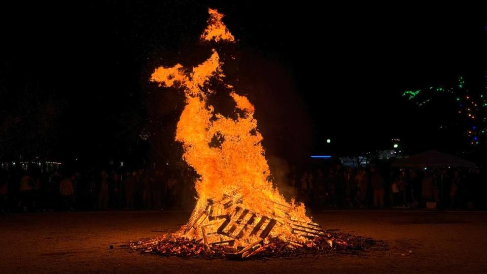 The giant bonfire throws flames into the air at Paso Robles’ New Year’s Eve celebration in the Downtown City Park on Dec. 31, 2023.