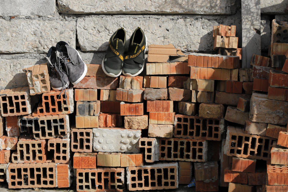 Shoes are placed on a pile of bricks to dry in the yard of the Topchu family house in a village on the outskirts of Burgas, Bulgaria, Monday, Sept. 28, 2020. Human rights activists and experts say local officials in several countries with significant Roma populations have used the pandemic to unlawfully target the minority group, which is Europe's largest and has faced centuries of severe discrimination. (AP Photo/Vadim Ghirda)