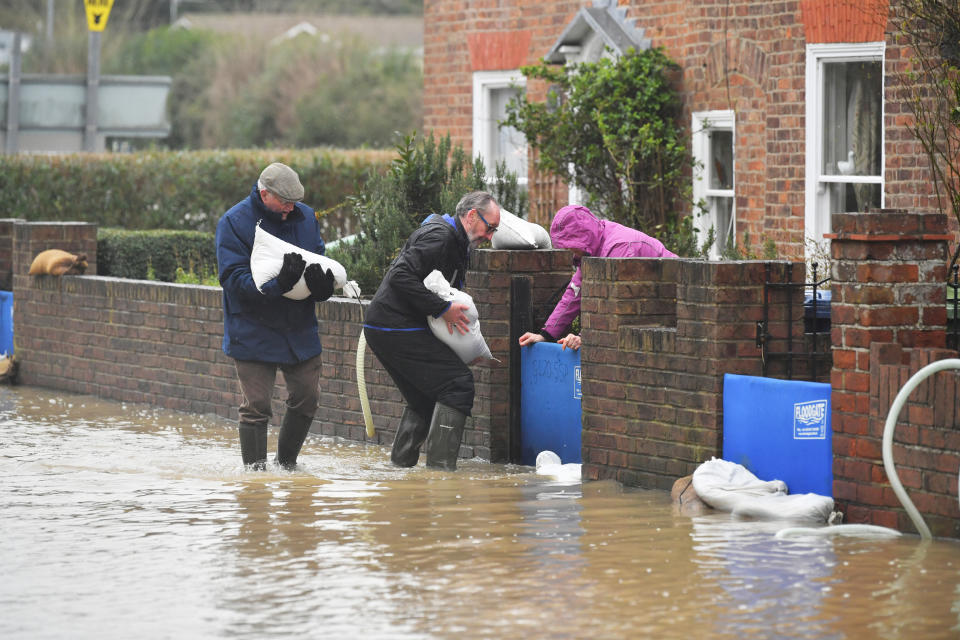 Residents picking up sandbags in Gloucester Road in Tewkesbury, Gloucestershire, where pumps and flood barriers have been put in to help to keep the water from flooding homes following the aftermath of Storm Dennis.