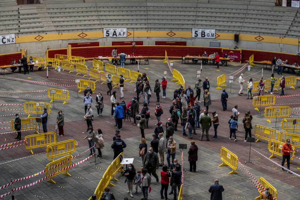 People queue to cast their votes during the regional election at the bullring in Moralzarzal, Spain, Tuesday, May 4, 2021. Over 5 million Madrid residents are voting for a new regional assembly in an election that tests the depths of resistance to lockdown measures and the divide between left and right-wing parties. (AP Photo/Manu Fernandez)
