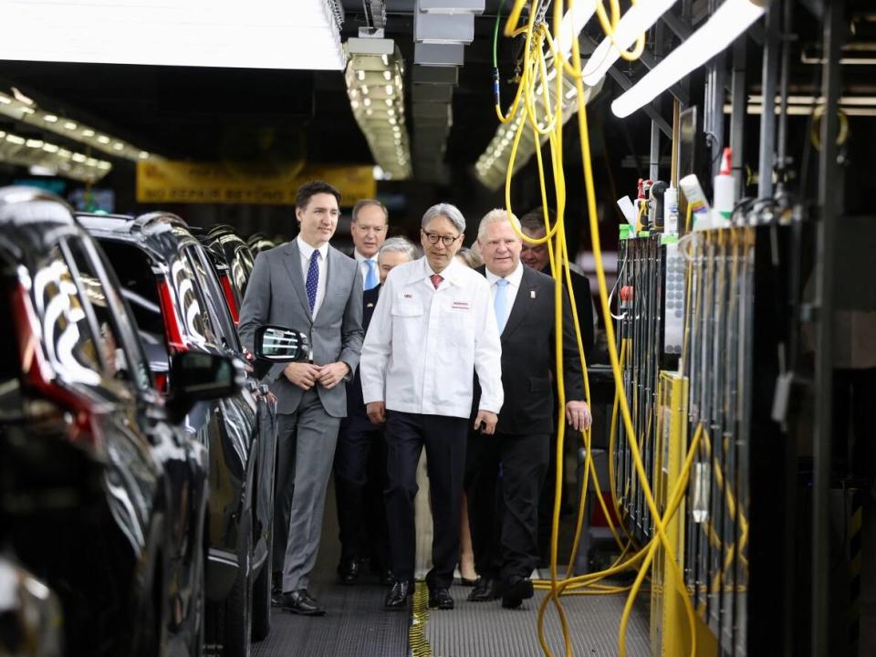 Prime Minister Justin Trudeau, left, Honda CEO Toshihiro Mibe, centre, and Ontario Premier Doug Ford, right, visit Honda's automotive assembly plant in Alliston, Ont., as the company announces plans to build electric vehicles and their parts in Ontario with financial support from the federal and provincial governments, on April 25, 2024.   (Carlos Osorio/Reuters - image credit)