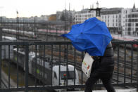 Eine Frau kämpft sich durch den Wind über die Donnersberger Brücke am Münchner Hauptbahnhof. Auch hier sind viele Züge stehengeblieben. (Bild: Reuters/Andreas Gebert)