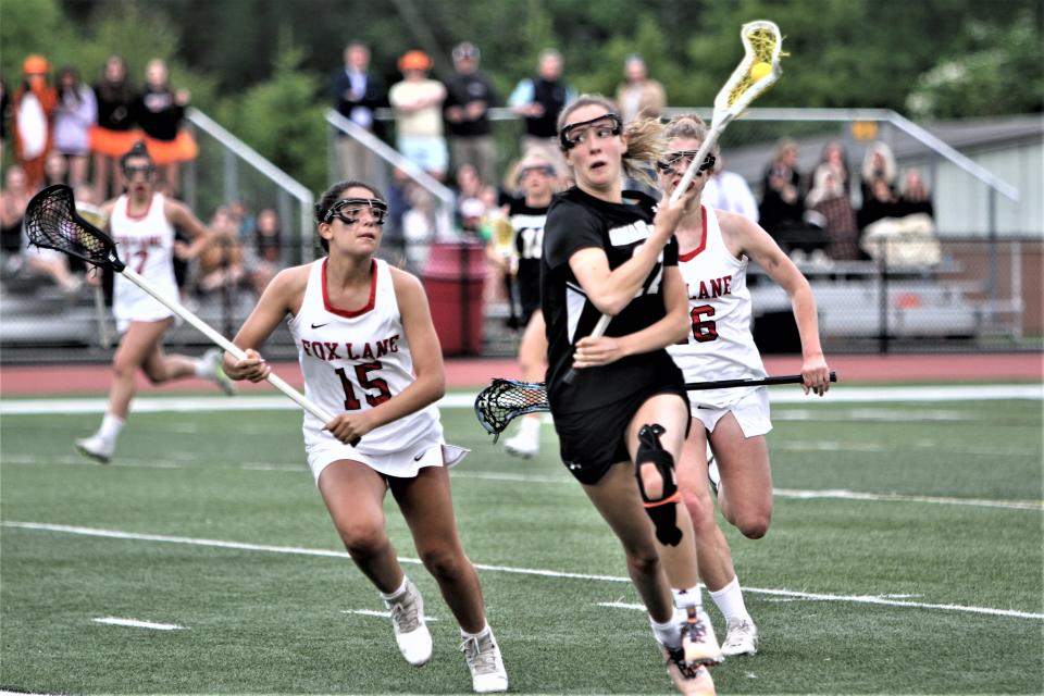 Mamaroneck's Clara Sosa (r) carries the ball, pursued by Fox Lane's Sophia Bueti (l), during Mamaroneck's 10-8 Section 1 Class A semifinal win May 23, 2022 at Fox Lane.