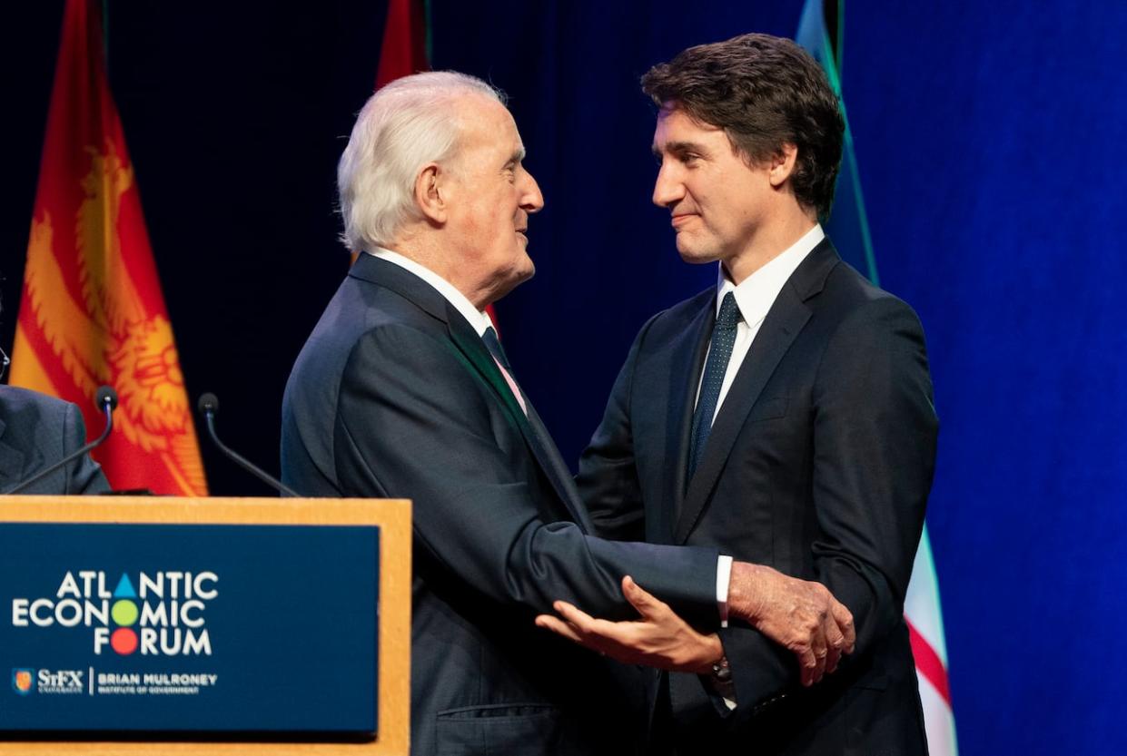 Prime Minister Justin Trudeau, right, and former prime minister Brian Mulroney share a moment on stage during the Atlantic Economic Forum at St. Francis Xavier University in Antigonish, N.S. on Monday, June 19, 2023. (Darren Calabrese/The Canadian Press - image credit)