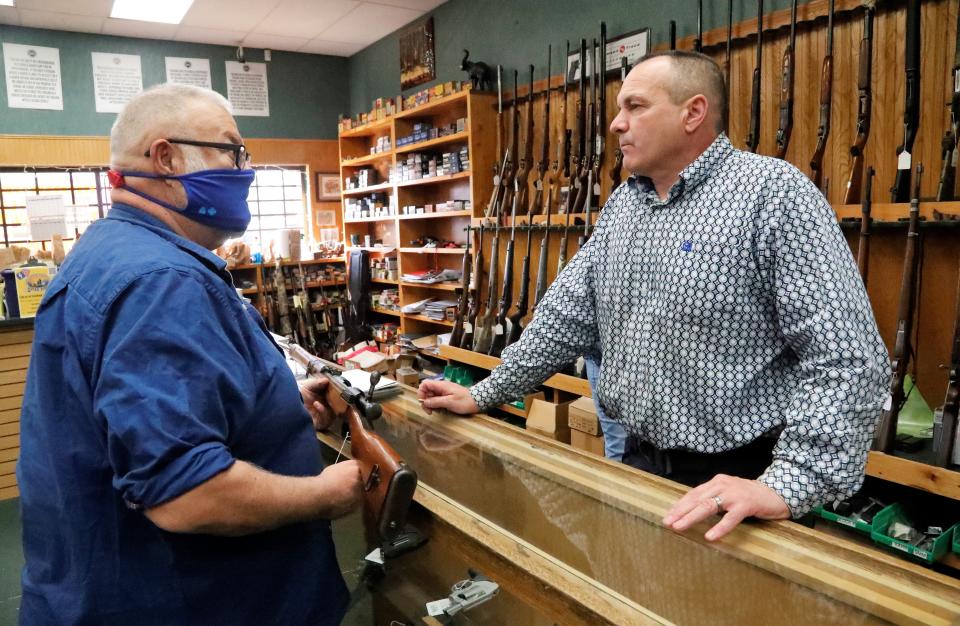 File photo - Steve Loughrey, left, holds a Japanese battle rifle from World War II while talking with Jones' Fort gun store manager and Shasta County Supervisor Patrick Jones on Thursday, March 4, 2021.