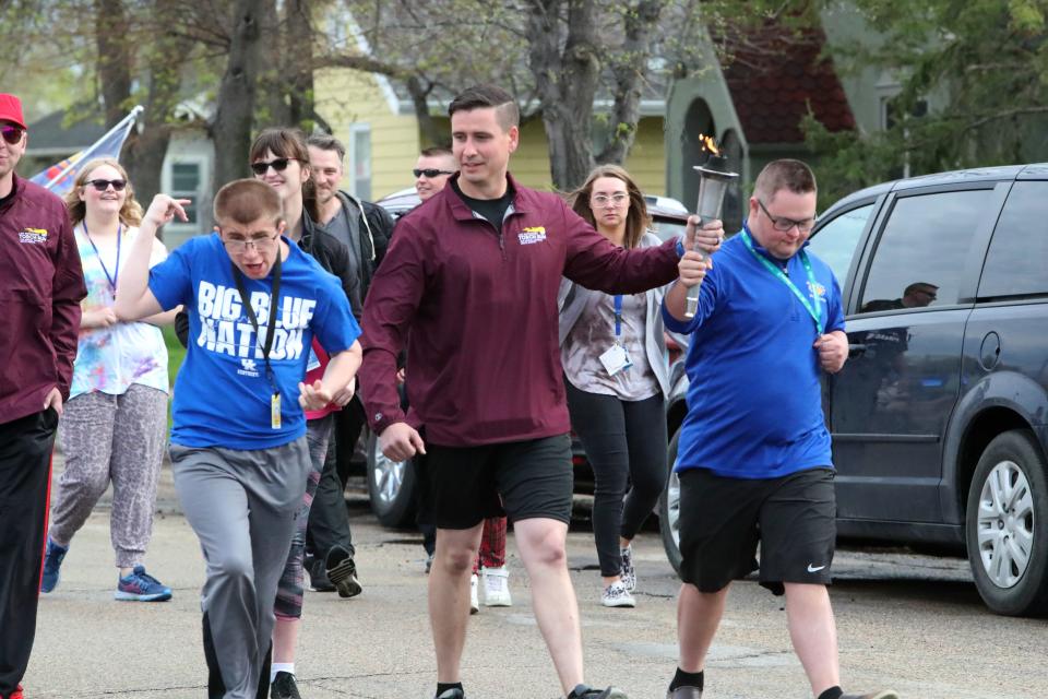 Jake Padgett, left, walks with Martin Geier and Ethan Stockert during the Special Olympics Law Enforcement Torch Run Tuesday morning in Aberdeen. The torch was carried down South Third Street from Simmons Middle School to Simmons Elementary. The Special Olympics Summer Games are this weekend in Spearfish.