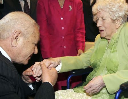 Albanian Xhemil Cala (L) puts the ring of the British flight engineer Sergeant John Thompson, onto the finger of his sister Dorothy Webster, 92, during a ceremony held at the Ministry of Defence in Tirana March 9, 2015. REUTERS/Arben Celi