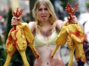 An activist of the animal rights group PETA (People for the Ethical Treatment of Animals) protests with blood-smeared plastic chickens against the fast food chain KFC in Nuremberg, southern Germany on August 11, 2011. AFP PHOTO / DANIEL KARMANN