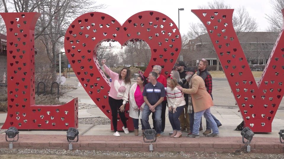 Volunteers pose for a photo in front of a “Love” art installation at the visitors center in Loveland, Colo., on Wednesday, Feb. 7, 2024. Every year, tens of thousands of people from around the world route their Valentine’s Day cards to the “Sweetheart City” to get a special inscription and the coveted Loveland postmark. The re-mailing tradition has been going on for nearly 80 years and is the largest of its kind in the world. (AP Photo/Thomas Peipert)
