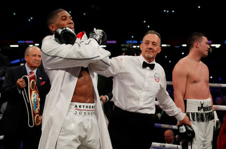 Boxing - Anthony Joshua vs Joseph Parker - World Heavyweight Title Unification Fight - Principality Stadium, Cardiff, Britain - March 31, 2018 Anthony Joshua celebrates after winning the fight as Joseph Parker looks dejected Action Images via Reuters/Andrew Couldridge
