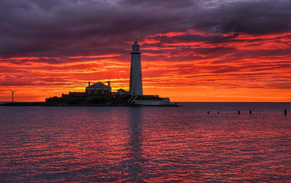 A fire coloured sky above St Mary’s Lighthouse in Whitley bay on the North East coast of England just before sunrise (Owen Humphreys/ PA) (PA Wire)