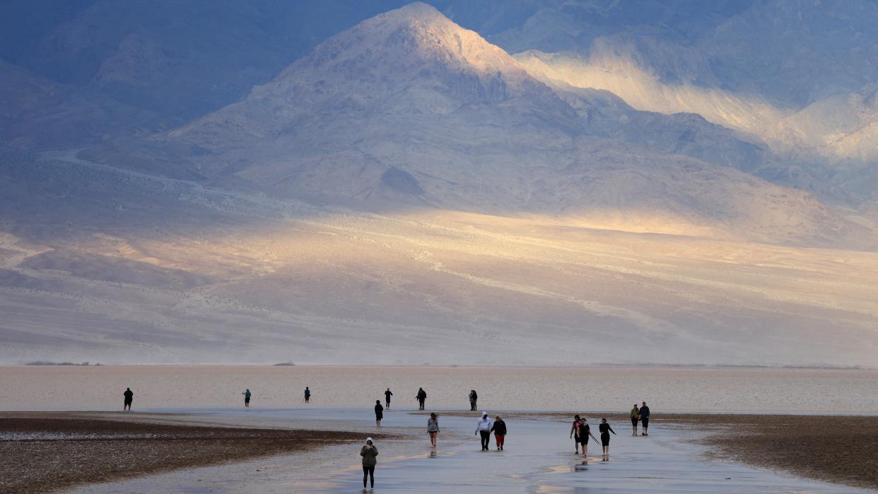 Ourists enjoy the rare opportunity to walk in water as they visit Badwater Basin, the normally driest place in the US. 