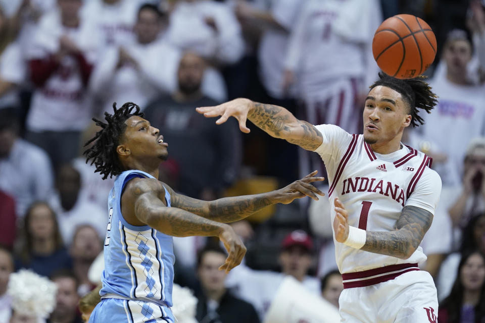 CORRECTS CITY TO BLOOMINGTON, INSTEAD OF INDIANAPOLIS - North Carolina guard Caleb Love, left, passes the ball past Indiana guard Jalen Hood-Schifino (1) during the second half of an NCAA college basketball game in Bloomington, Ind., Wednesday, Nov. 30, 2022. (AP Photo/Darron Cummings)