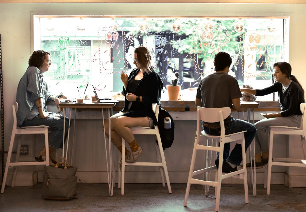 Customers enjoy their coffee and do remote work at the front window of Vagabond Coffee Co. on Wednesday morning.