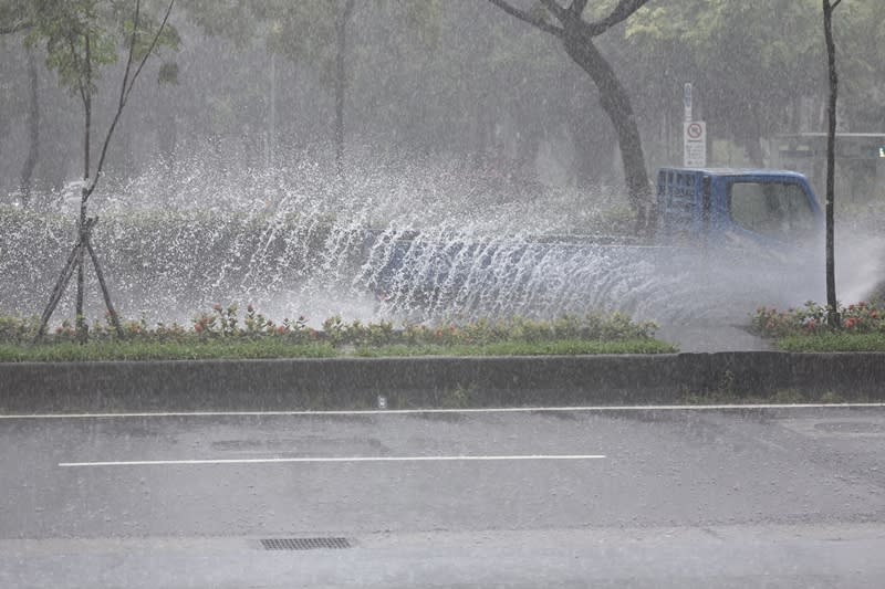 中央氣象署10日發布豪雨特報，午後對流雲系發展旺盛，台北市及新北市有局部大雨或豪雨發生的機率。圖為台北市內湖區一輛小貨車快速駛過濺起一大片水花。（中央社）