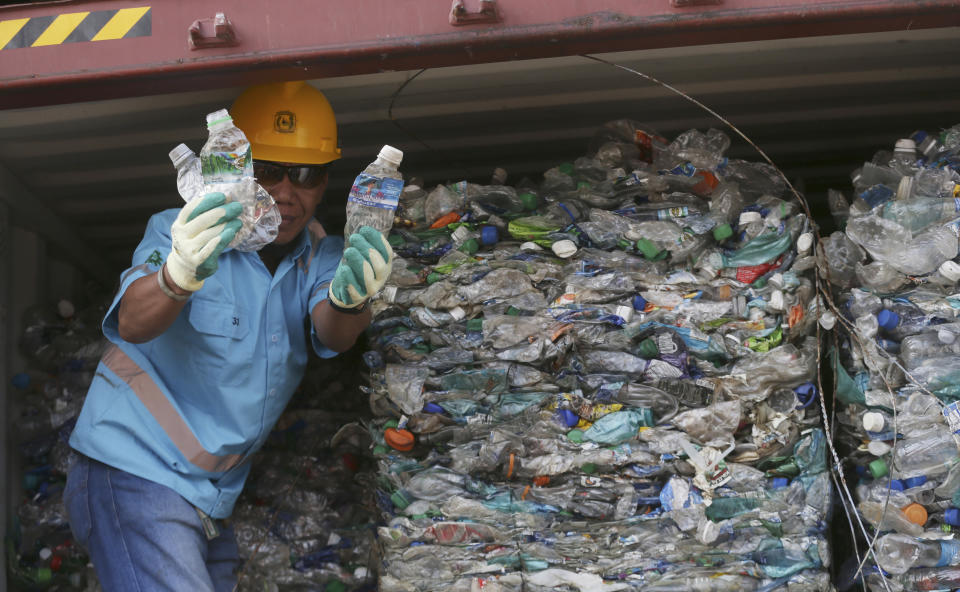 A worker shows plastic waste at Tanjung Priok port in Jakarta, Indonesia Wednesday, Sept. 18, 2019. Indonesia is sending hundreds of containers of waste back to Western nations after finding they were contaminated with used plastic and hazardous materials. (AP Photo/Achmad Ibrahim)