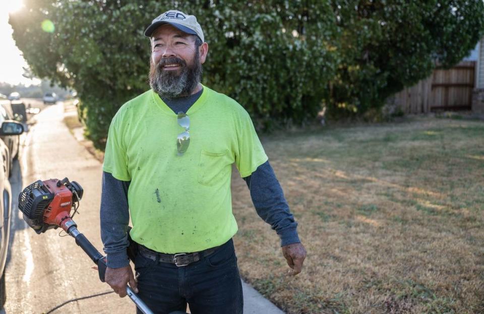 Gardener Rafael Gonzalez holds a gas-powered trimmer while he works on a customer’s yard in Sacramento in August. He said he would have to increase his rates to invest in battery-powered electric equipment.