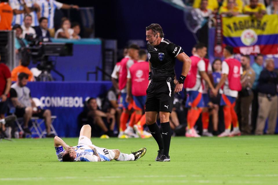 Argentina forward Lionel Messi waits on the field to be attended to by trainers on Sunday.