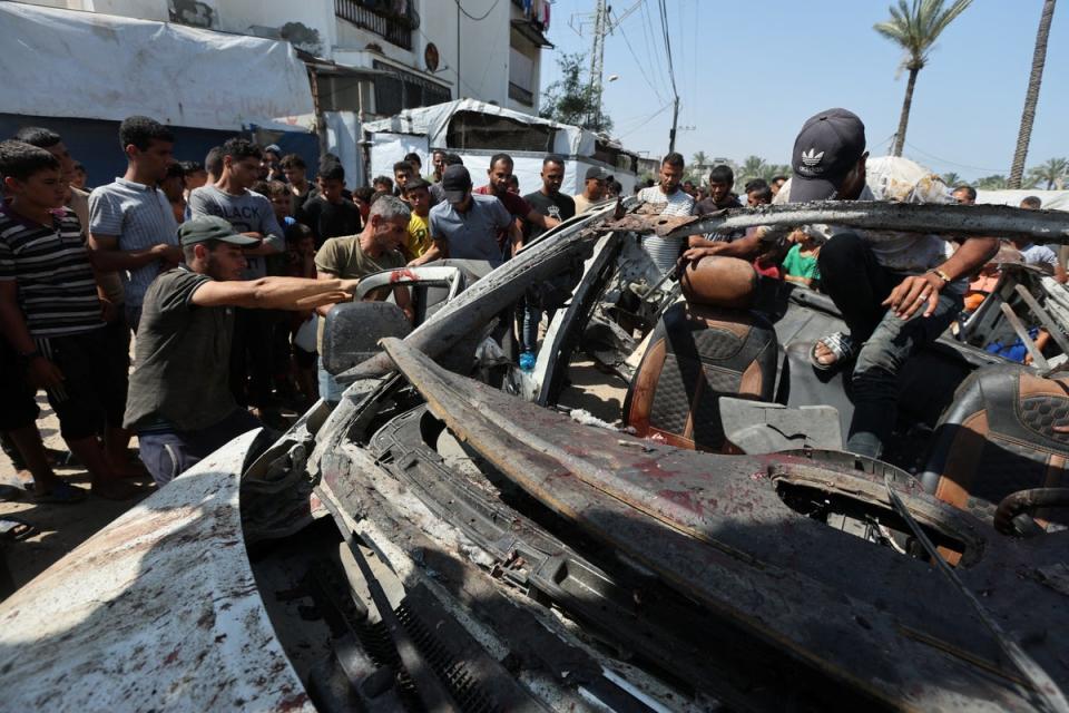 Palestinians inspect a vehicle hit in an Israeli strike in Deir Al-Balah in the central Gaza Strip (REUTERS)