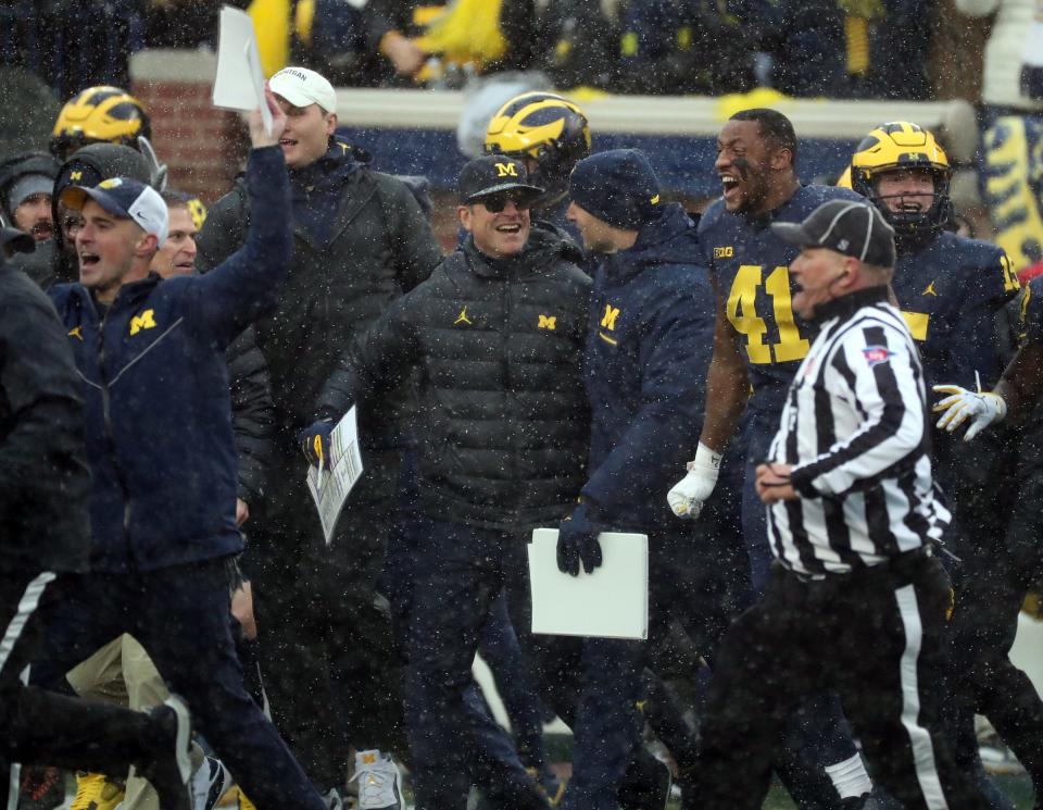 Michigan Wolverines head coach Jim Harbaugh, center, celebrates the 42-27 win against the Ohio State Buckeyes, Saturday, Nov. 27, 2021 at Michigan Stadium.