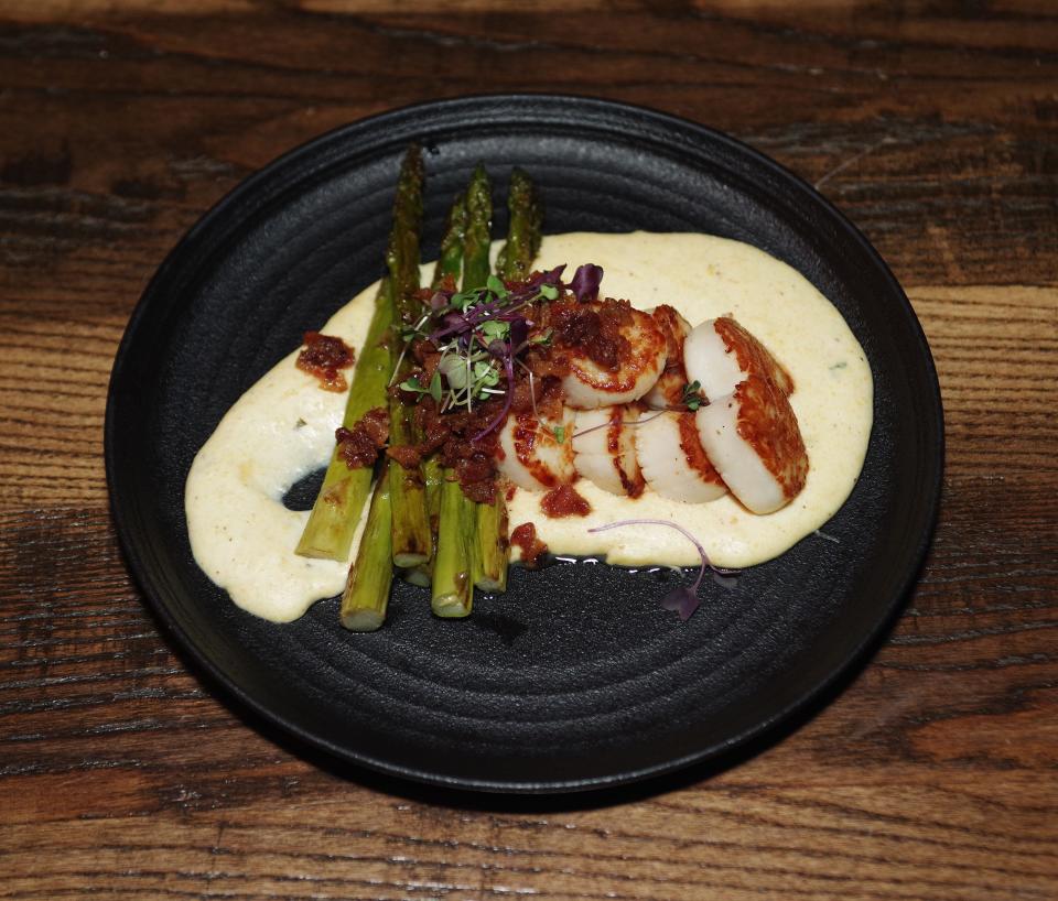 Seared scallops with bacon jam, asparagus and creamy polenta is available at Barrels & Boards restaurant in Raynham, shown Thursday, Dec. 28., 2023.