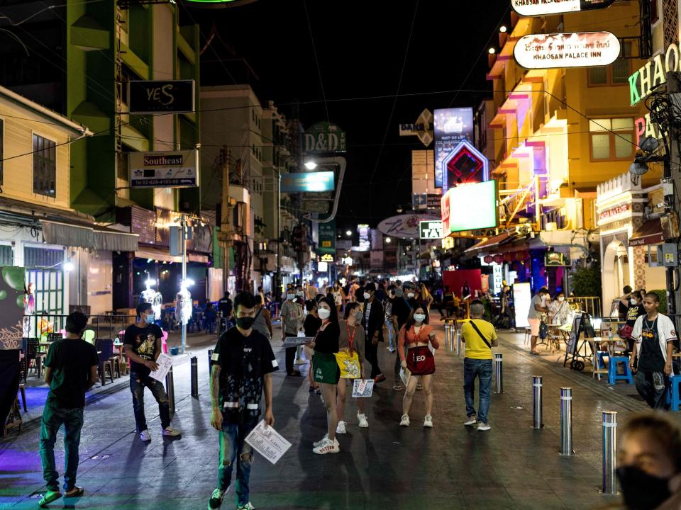 Bar and restaurant workers wait for customers along the popular tourist and nightlife strip Khao San Road in Bangkok on December 10, 2021.