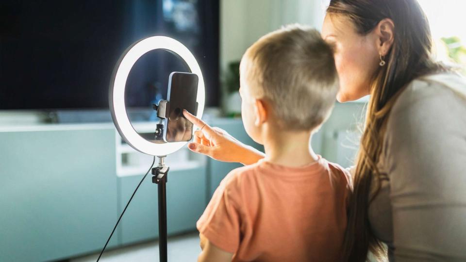 PHOTO: A stock photo shows a mother setting up a ring light and a mobile phone for live streaming with her son. (STOCK PHOTO/Getty Images)
