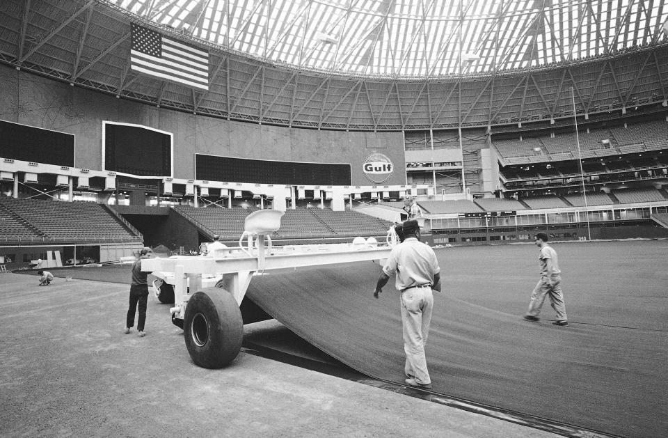 FILE - Workers lay AstroTurf at the Astrodome in Houston, July 13, 1966. Artificial turf has come a long way since since it was introduced on a grand stage to the sports world at the Astrodome. (AP Photo/Ed Kolenovsky, File)