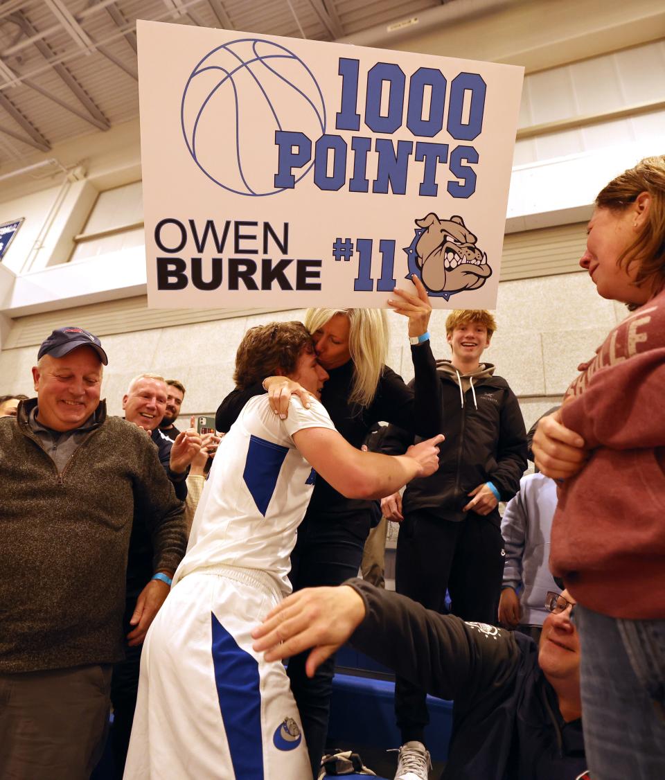 Holbrook's Owen Burke gets a kiss from his mother, Melissa Burke, as they celebrate after he scored his 1,000th career point during a game against South Shore Christian Academy on Friday, Jan. 13, 2023.