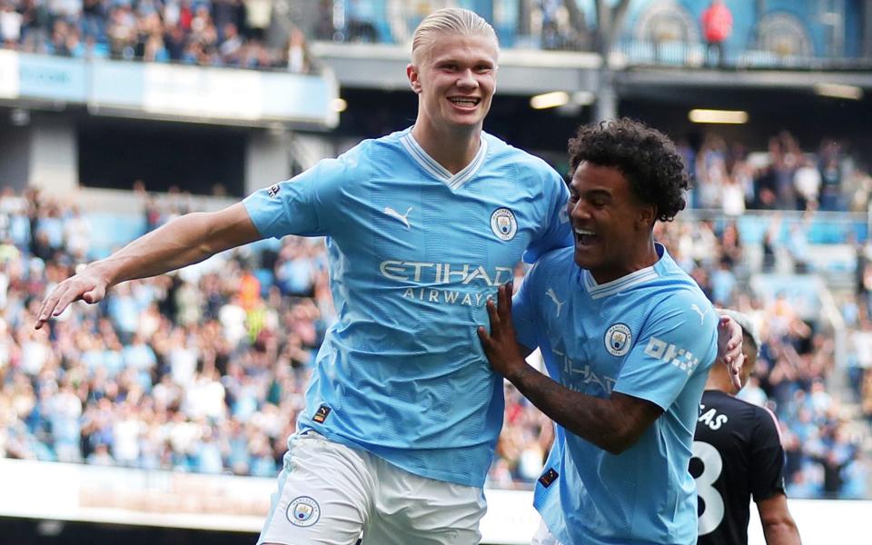 Erling Haaland of Manchester City celebrates with his teammate Oscar Bobb after scoring the team's fifth goal and his hat-trick during the Premier League match between Manchester City and Fulham FC at the Etihad Stadium on September 2, 2023 in Manchester, England.