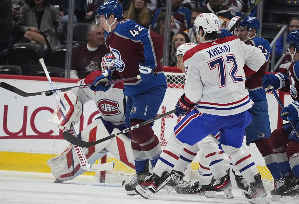 Colorado Avalanche defenseman Josh Manson, front left, tries to redirect the puck at Montreal Canadiens goaltender Sam Montembeault, back, as defenseman Arber Xhekaj cover in the second period of an NHL hockey game Tuesday, March 26, 2024, in Denver. (AP Photo/David Zalubowski)