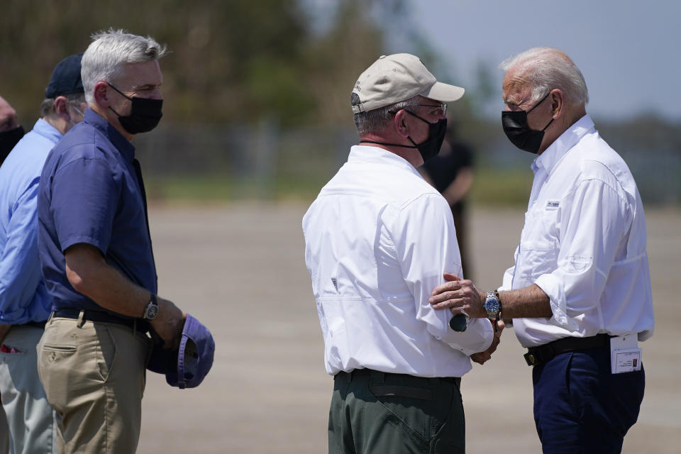 President Joe Biden talks with Louisiana Gov. John Bel Edwards and as Sen. Bill Cassidy, R-La., left, listens as Biden arrives at Louis Armstrong New Orleans International Airport in Kenner, La., Friday, Sept. 3, 2021, to tour damage caused by Hurricane Ida. (AP Photo/Evan Vucci)
