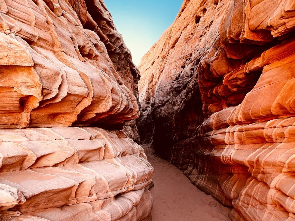 Beautiful, striped red-rock formations with a narrow path in between.